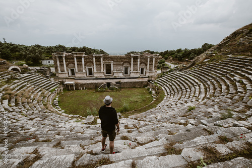 Traveller young man wearing hat watching the Nysa ancient city theater