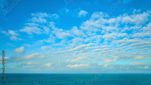 Blue sky with wispy white clouds, dream and inspiration over blue Lake Michigan water, inspire