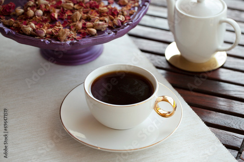 Fresh cup of filter coffee and milk glass on a wooden table with decoration outdoor daytime.