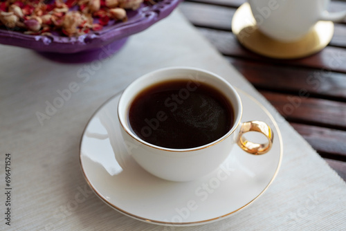 Fresh cup of filter coffee and milk glass on a wooden table with decoration outdoor daytime.