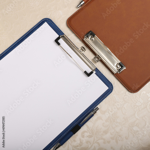 Colorful leather clipboard. Genuine leather clipboard  concept shot  top view  different color  woman about to write a note on empty blank with a pen.
