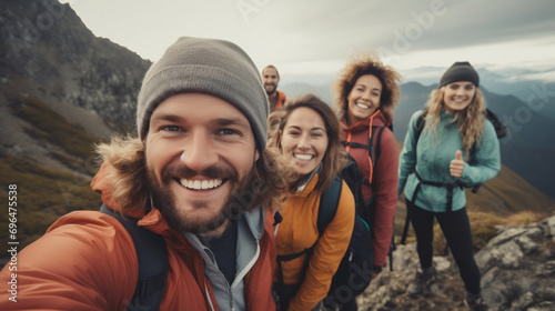 Young group of hiker friends taking selfie portrait on the top of mountain