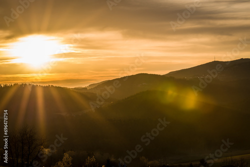 Ausblick von Haus im Wald zu dem Berg Brotjacklriegel im Bayerischen Wald bei Grafenau in Niederbayern während Sonnenuntergang und goldene Stunde, Deutschland © stgrafix
