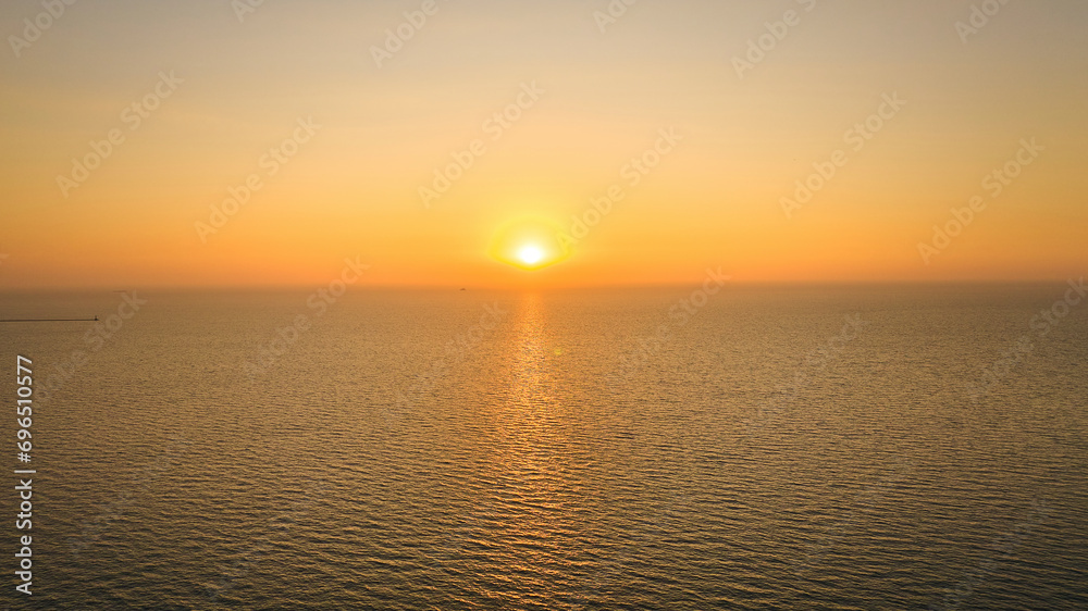 Aerial over water with inspiring sun rising over great Lake Michigan, sunrise at dawn, Chicago, IL