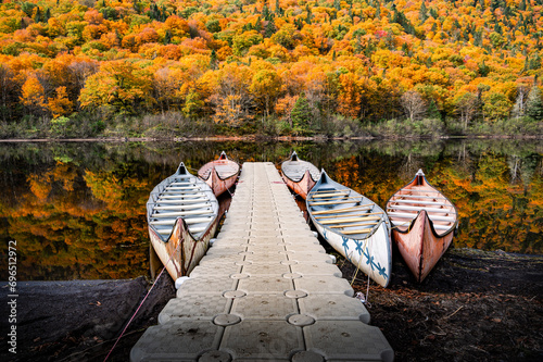 Canoes docked to a quay on the shores of Jacques Cartier river on a wonderful and colorful Fall day, QC, Canada