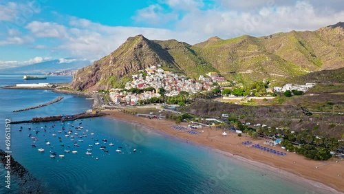 View from above of ships and beaches by the colourful houses on a mountain in San Andrés, Canary Islands. Aerial view of Playa de Las Teresitas and San Andrés village in Tenerife, Spain. photo