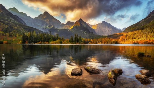 awesome nature landscape beautiful scene with high tatra mountain peaks stones in mountain lake calm lake water reflection colorful sunset sky amazing nature background autumn adventure hiking