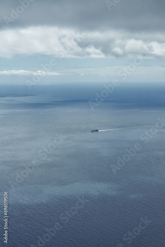 a cargo ship on the Atlantic  nothing but water and sky around the ship  minimalistic