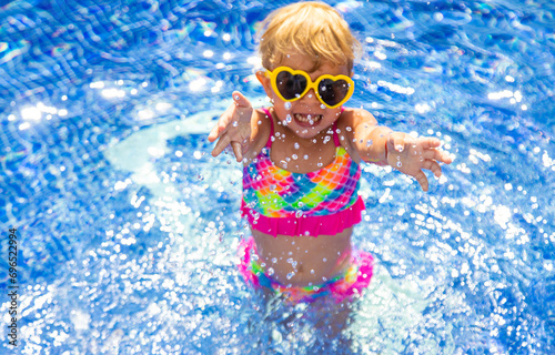 Child near the pool in sunglasses. Selective focus.