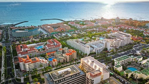 Aerial view of Playa de las Américas upscale resort and luxury hotels in Tenerife. View from above of a coastal resort district with sandy beaches and colourful villas in the Canary Islands, Spain. photo