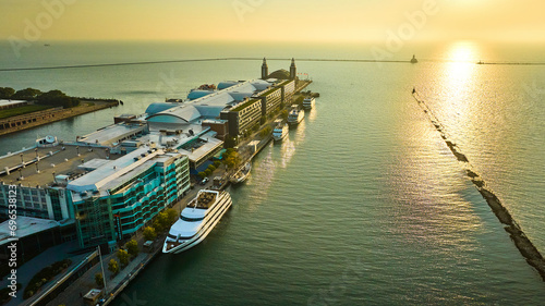 Boat docked Navy Pier on Lake Michigan sunrise aerial in summer dawn, Chicago, IL