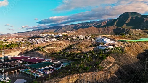 Aerial view of Playa de las Américas upscale resort and luxury hotels in Tenerife. View from above of a coastal resort district with sandy beaches and colourful villas in the Canary Islands, Spain. photo