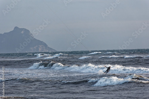 kite surfers ride the waves. Winter sport with high waves and many dangers. Wind and wave speed. Men and women do extreme sports People water sport lessons and beach swimming activity. 