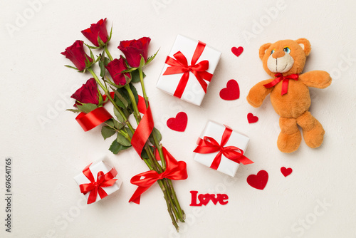 Red rose flowers with gift box and soft toy on concrete background, top, view. Valentine's day concept