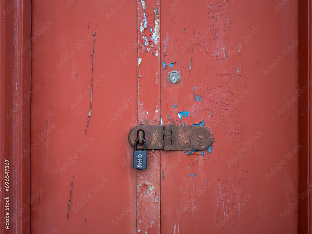 21 December 2023. Lossiemouth,Moray,Scotland. This is a red doorway to an old pub which is padlocked closed with a chubb, yale and squire lock.