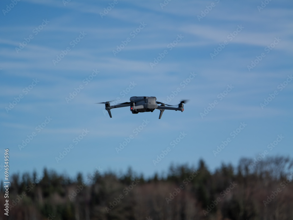 Drohne im Flug vor blauem Himmel und WaldgebietDrohne im Flug vor blauem Himmel und Waldgebiet Drohne im Flug vor blauem Himmel und WaldgebietDrohne im Flug vor blauem Himmel und Waldgebiet