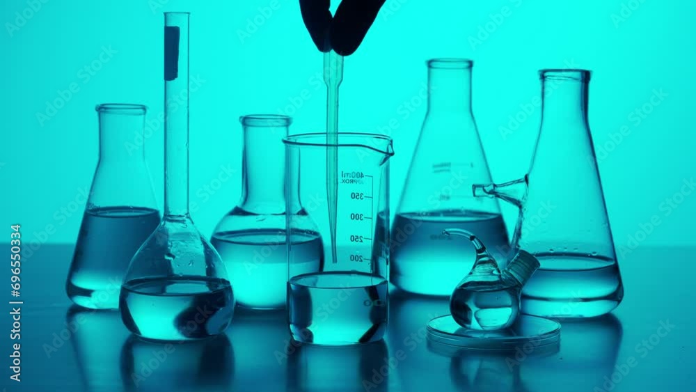 Laboratory table with many different beakers and flasks, scientist