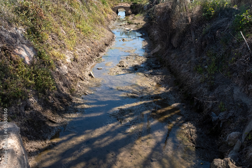 Ditch. Irrigation channel with water residues.