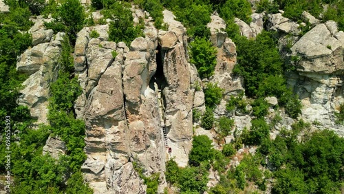 Drone view over Ancient Thracian sanctuary - Utroba cave above Kardzhali dam. Entrance to a cave in the form of a narrow slit through which a panoramic view can be seen photo