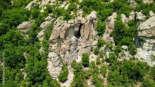 Drone view over Ancient Thracian sanctuary - Utroba cave above Kardzhali dam. Entrance to a cave in the form of a narrow slit through which a panoramic view can be seen photo