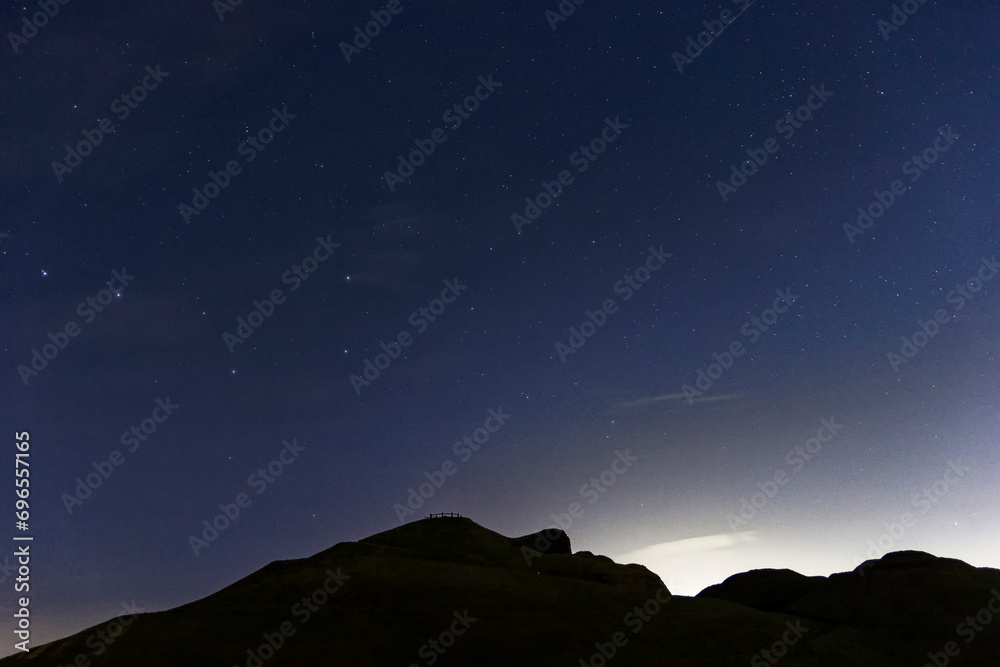 Northumberland night sky over Northumberlandia with stars, cloud and light pollution.