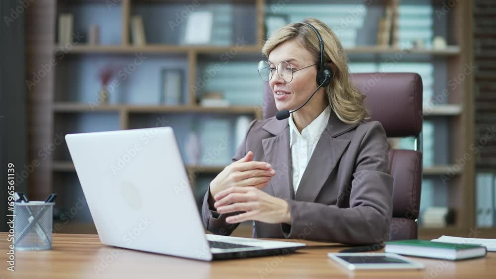 Mature woman lawyer gives advice online via video call. Female tutor, customer consultant psychologist use laptop microphone works in psychological support service advising people Internet in office Mature woman lawyer gives advice online via video call. Female tutor, customer consultant psychologist use laptop microphone works in psychological support service advising people Internet in office