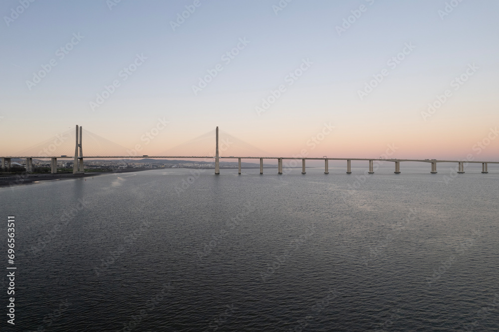 sunset over the ocean and second longest in europe bridge vasco da gama in lisbon portugal