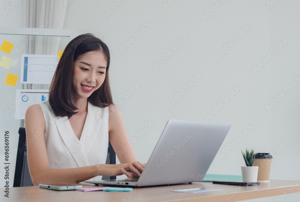 Business portrait woman girl asian one person wearing white dress smile sitting chair on desk looking notebook ready for working idea new project job online sale inside home office with intention Business portrait woman girl asian one person wearing white dress smile sitting chair on desk looking notebook ready for working idea new project job online sale inside home office with intention