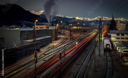 the arrival of the train at the station with the Alps in the background.