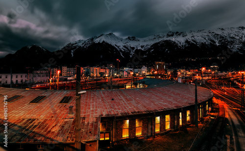 view of the railway station at night with the Alps in the background.