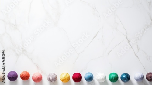  a row of balls of yarn sitting next to each other on a white counter top with a line of balls of yarn in front of them.