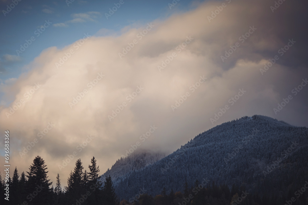 clouds over the frozen forest at sunrise. Transylvania, Romania. Mountain scenery in the Transylvanian Alps in autumn, with mist clouds. 