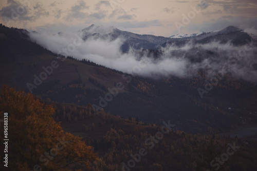 clouds over the frozen forest at sunrise. Transylvania, Romania. Mountain scenery in the Transylvanian Alps in autumn, with mist clouds. 