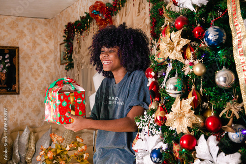 Latin Girl holding a present and smiling photo