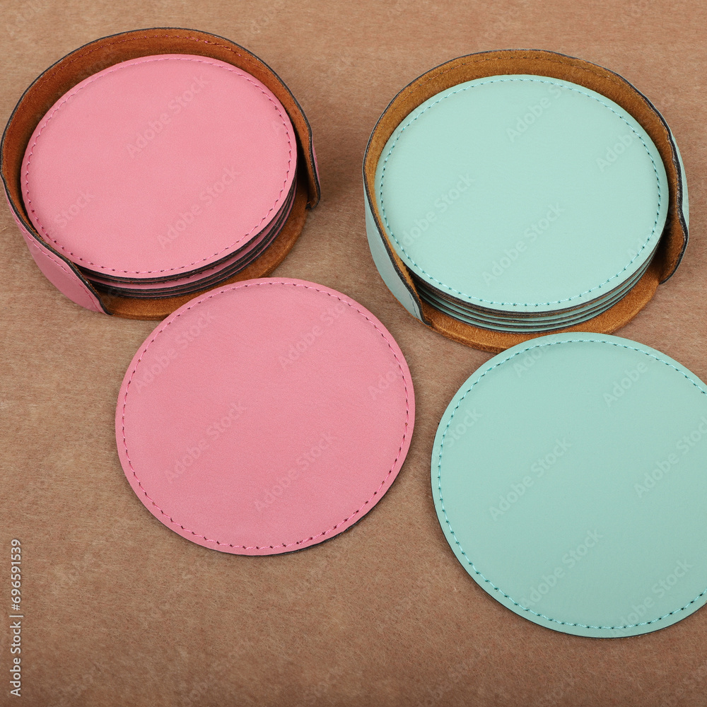 Leather table mats in teal and pink colors. Concept shot, top view. Custom background view of leather table coaster. Stitched and leather table coaster Leather table mats in teal and pink colors. Concept shot, top view. Custom background view of leather table coaster. Stitched and leather table coaster
