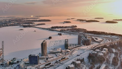 Espoo.Finland-February 3.2022: Aerial shot of the cityscape of Keilaranta in Espoo Finland during wintertime. Frozen sea. Different buildings. Snowy city. Drone slowly moving backwards.