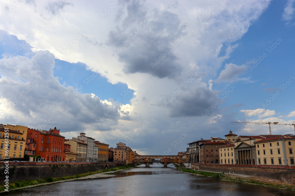 Häuser am Arno und Ponte Vecchio unter malerischen Wolken in Florenz