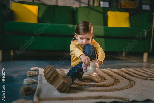Canvastavla girl toddler child puts on her own boots in the winter at home