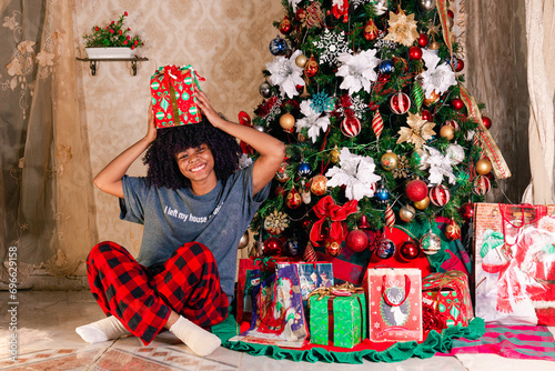 Latin girl surrounding with presents sitting in the ground