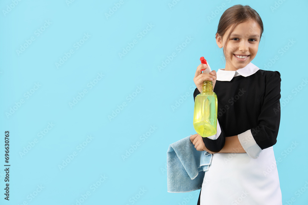 Cute little chambermaid with detergent and rag on blue background Cute little chambermaid with detergent and rag on blue background
