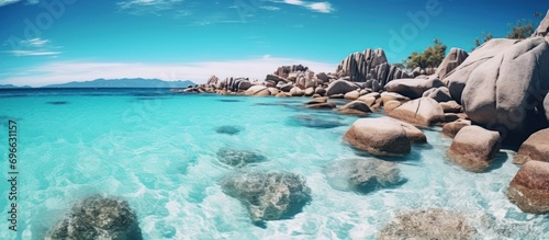 Perfect beach panorama with white sand, unique large granite rocks, turquoise sea water and blue sky