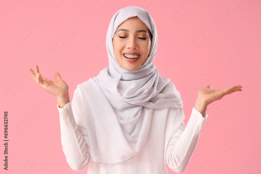 Beautiful Muslim woman in hijab on pink background Beautiful Muslim woman in hijab on pink background
