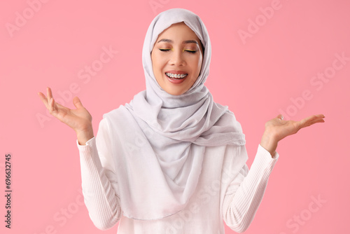 Beautiful Muslim woman in hijab on pink background