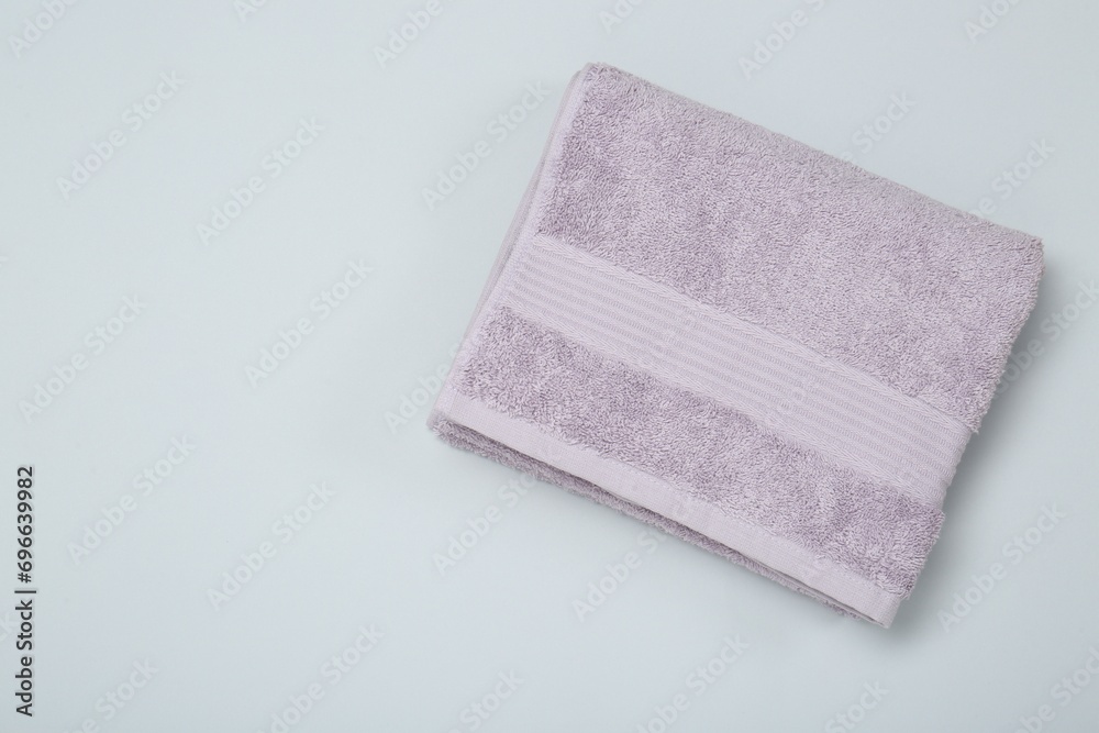 Violet terry towel on light grey background, top view. Space for text Violet terry towel on light grey background, top view. Space for text