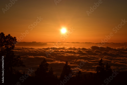 Słońce tuz przed zachodem tuż ponad chmurami w parku Teide na Teneryfie photo