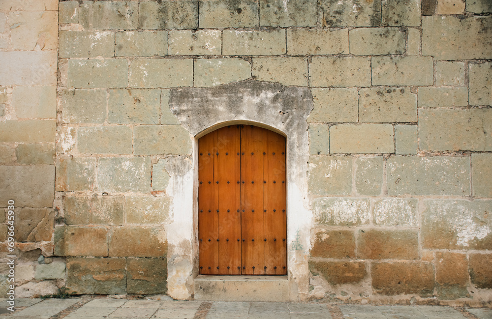 Beautiful green quarry façade and old wooden door, in Santo Domingo, Oaxaca, Mexico.