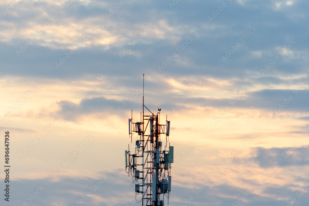 Telecommunication tower with sunset sky background. Telecommunication tower with antennas.