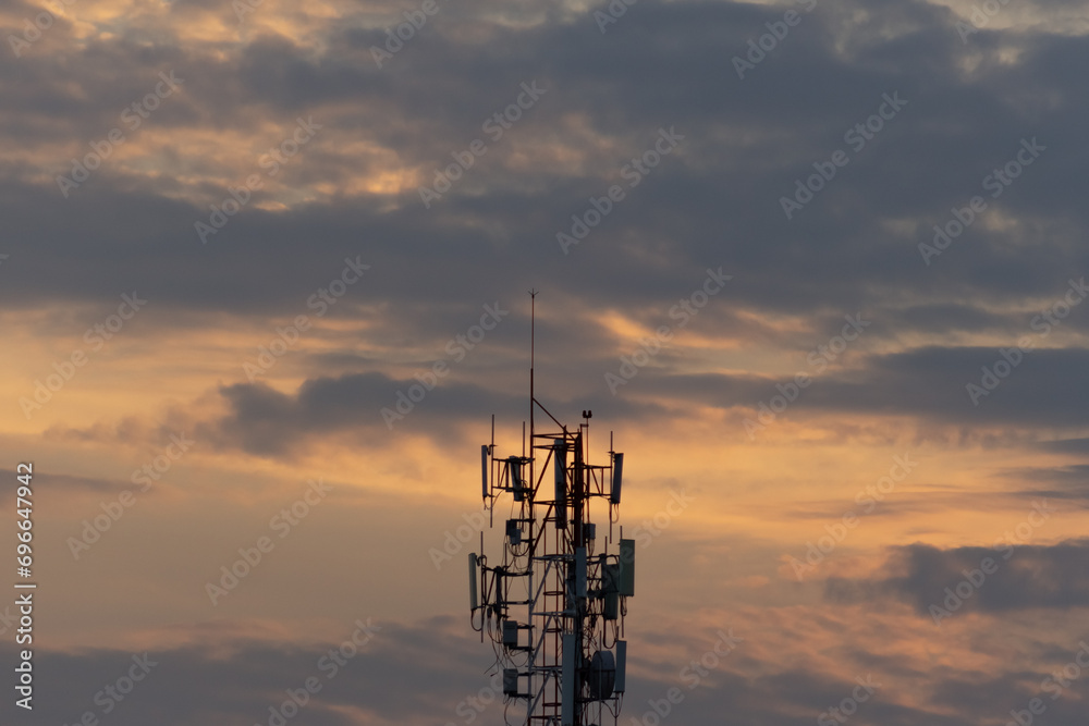 Telecommunication tower with sunset sky background. Telecommunication tower with antennas.