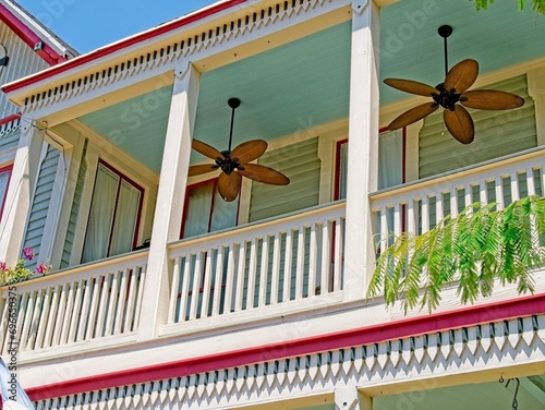 Outdoor wooden fans attached to a blue ceiling provide cooling respite for balcony enjoyment in Galveston Island, Texas.