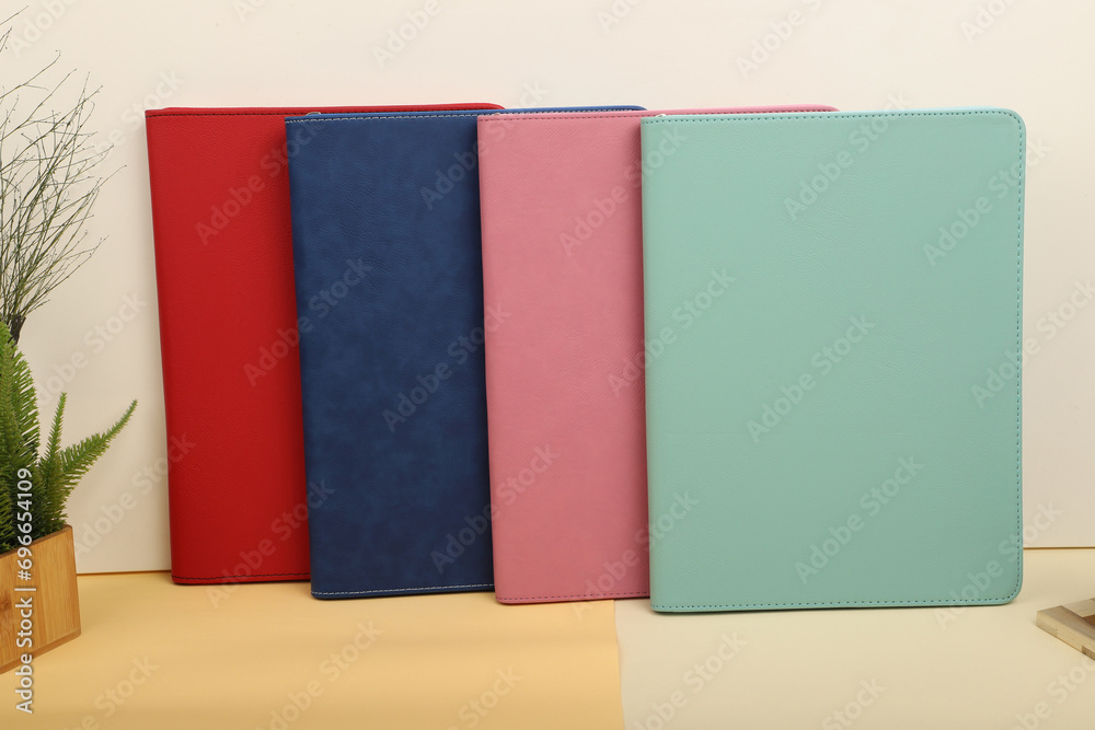 Leather Zipper Portfolio. Concept shot, top view, flap portfolio in different colors and leather pen. Custom background flap portfolio view. Zipper portfolio on desktop. Leather Zipper Portfolio. Concept shot, top view, flap portfolio in different colors and leather pen. Custom background flap portfolio view. Zipper portfolio on desktop.